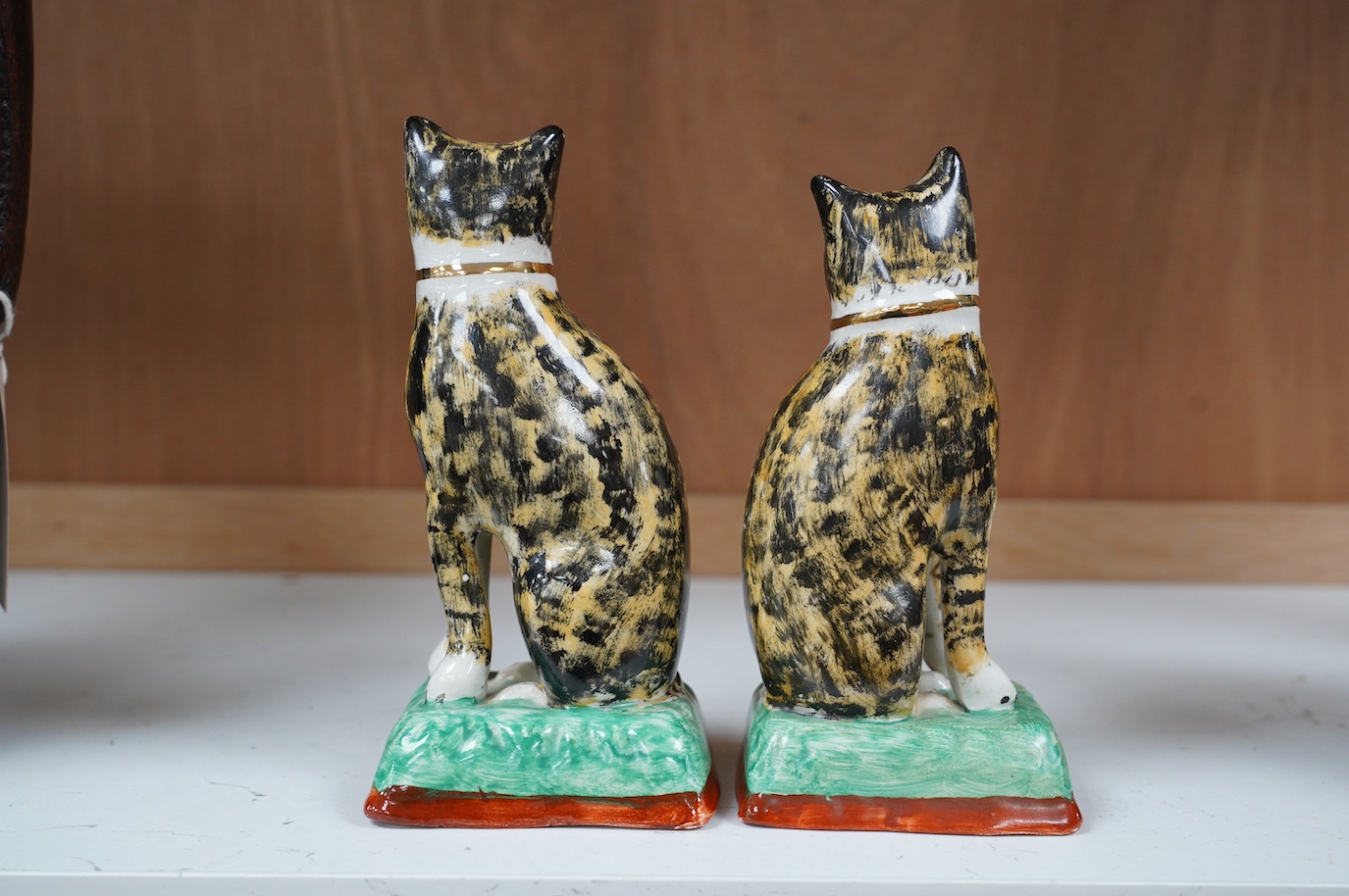 A pair of early 20th century Staffordshire cats, 17cm. Condition - good, some crazing